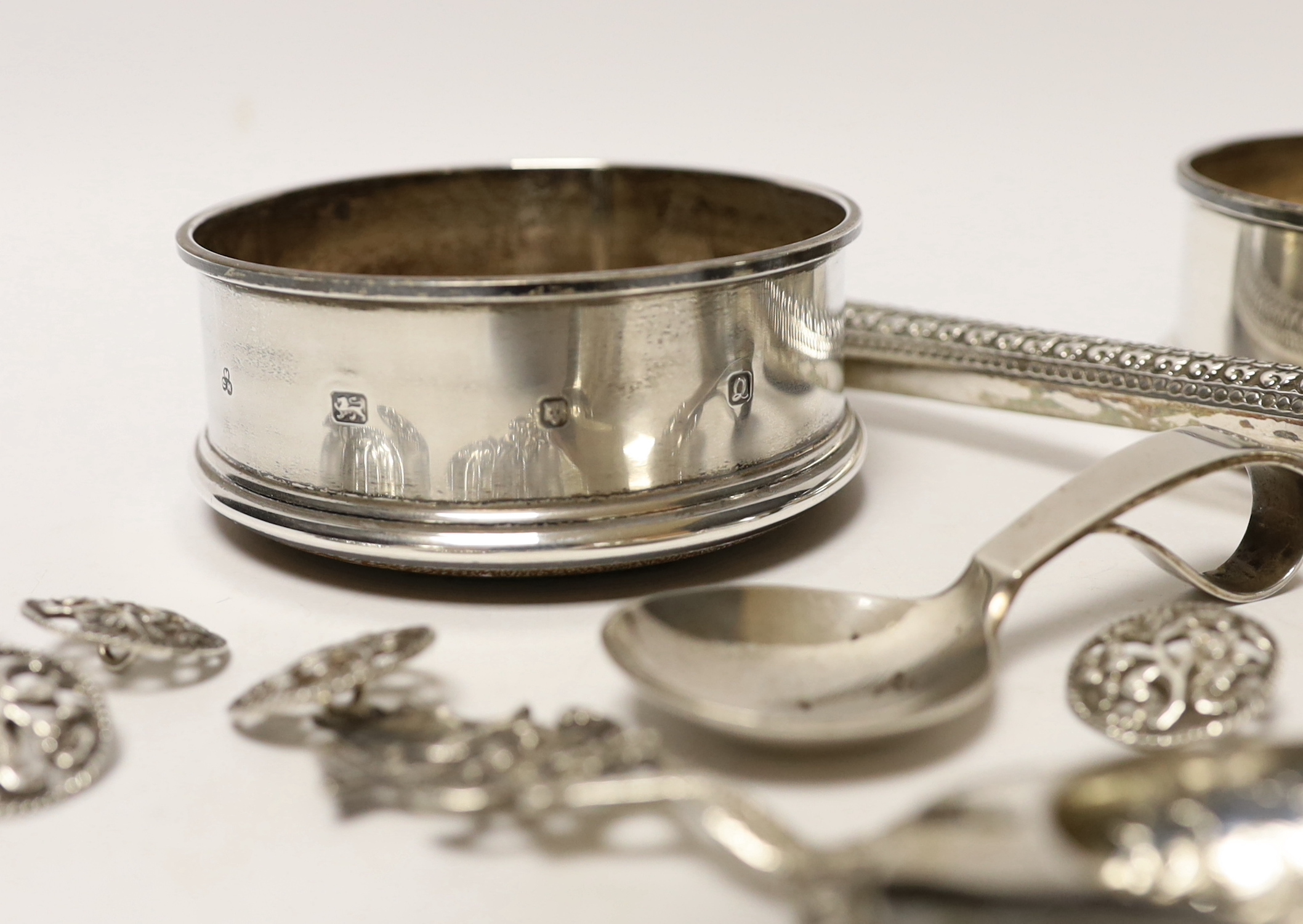 A Georg Jensen silver christening spoon, a pair of modern silver wine coasters, a set of five silver buttons and two white metal spoons, one stamped 800.